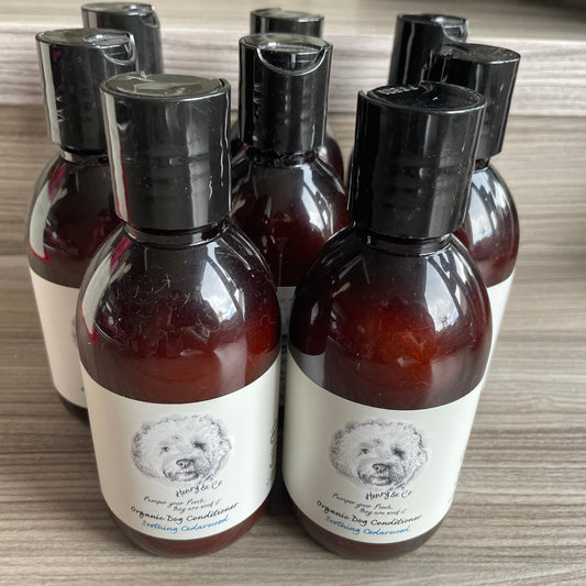 Bottles of Henry & Co Organic Soothing Cedarwood Conditioner with black caps and labels featuring an image of a dog.
