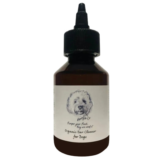 A bottle of Henry & Co Organic Ear Cleaner for Dogs with a label featuring an illustration of a dog's head. The bottle has a black cap and a white dropper, and it's adorned with a silver award sticker stating 'Winner 2020'.
